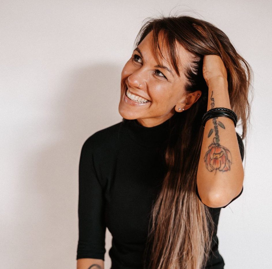 Steffi Voss mit schwarzem Pulli fährt sich mit der Hand durch's Haar quadratisch